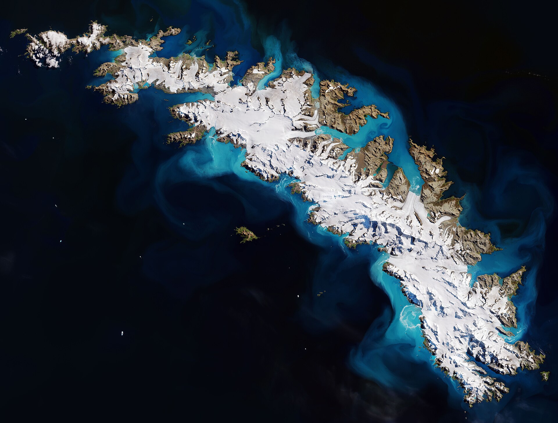 A Copernicus Sentinel-2 image of South Georgia Island: snow-covered mountain ridges and glaciers running the length of the island, surrounded by dark ocean.